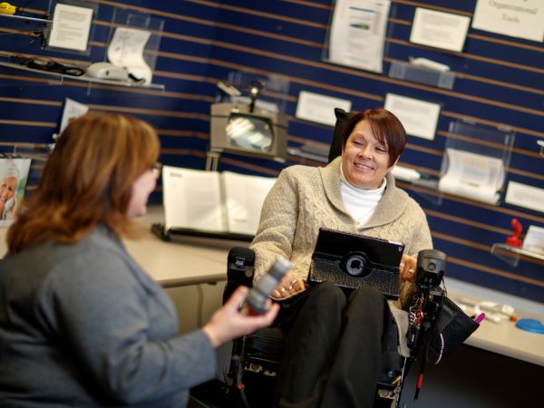 Jill Flagel, Coordinator, Faculty/Staff Disability Services, Office of Institutional Equity and Compliance, discusses accessibility devices with coworkers. January 17, 2017. Photo by Craig Chandler / University Communication.