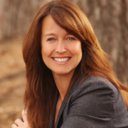Smiling white woman with long brown hair and a dark gray jacket.
