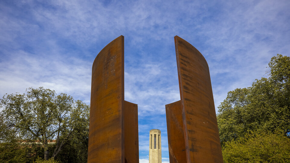 The Mueller Bell Tower is framed by the Greenpoint sculpture. City Campus. October 28, 2020. Photo by Craig Chandler / University Communication.