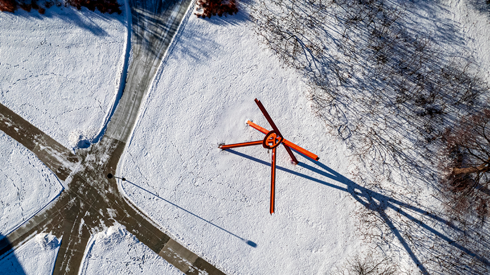 This large red sculpture of I-beams and metal by Mark Di Suvero was installed on campus in 1987. Laying below it, against a blue sky with scattered clouds, it represents the American flag.