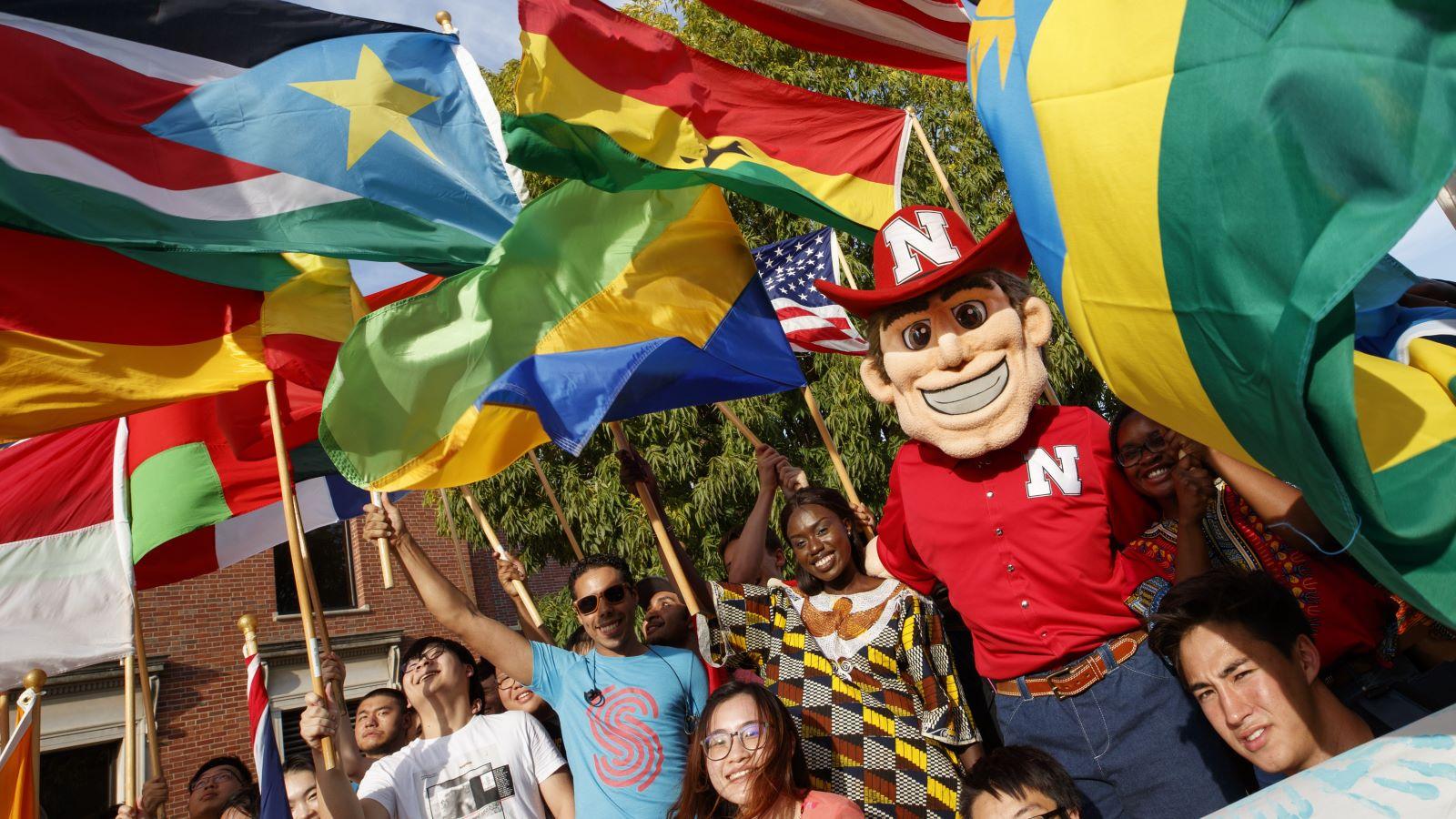 Herbie Husker and UNL international students fly the flags of various countries.